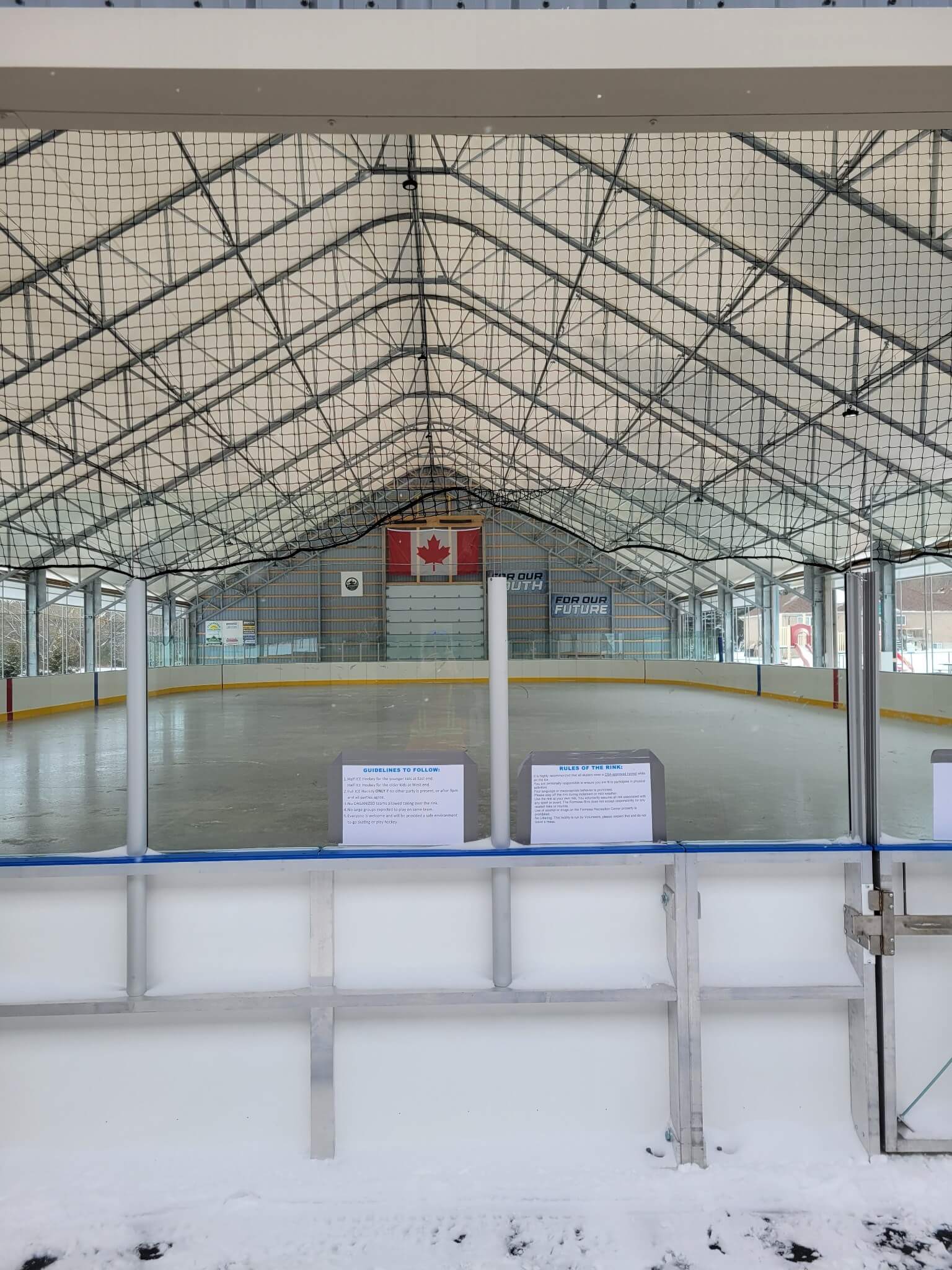 Shot of hockey rink from behind the goal looking down to the other end of the ice